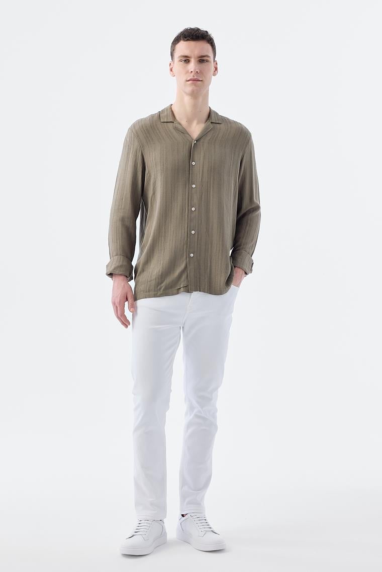 Man wearing a green shirt and white pants on a white background